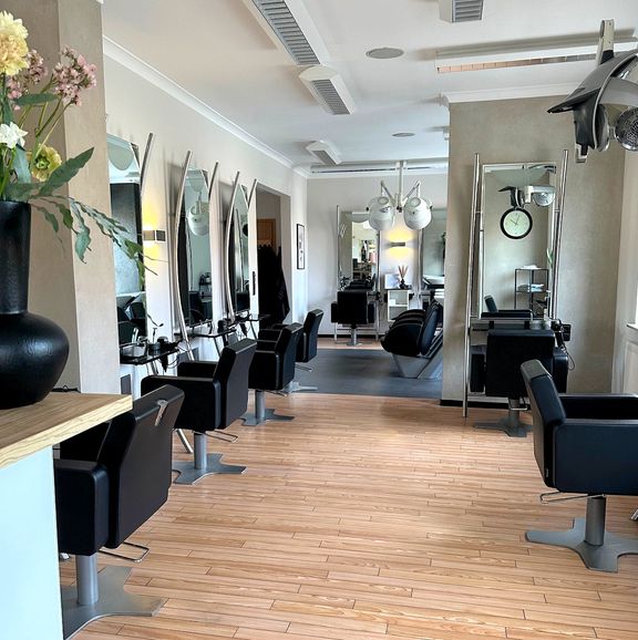 Blick durch den Salon auf die Frisierplätze mit Spiegeln